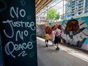 Menschen gehen am 11. Juni 2020 an einem Wandgemälde von George Floyd in der Graffiti Alley in der Innenstadt von Toronto vorbei. Die bekannte Gasse von Toronto war mit prominenten schwarzen Figuren und Solidaritätsbotschaften gegen Rassismus gegen Schwarze bemalt. 
