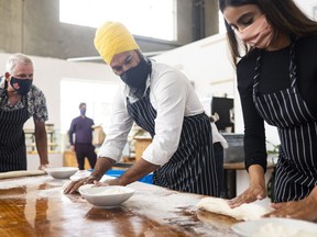 Jagmeet Singh and his wife, Gurkiran Kaur, learn to make bread during a campaign event at a bakery in Coquitlam, B.C. on Aug. 17, 2021.