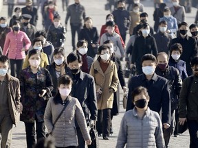 People wearing protective face masks commute amid concerns over the new coronavirus disease (COVID-19) in Pyongyang, North Korea March 30, 2020, in this photo released by Kyodo.