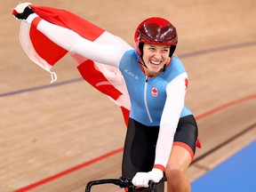 Kelsey Mitchell of Canada celebrates with a national flag after winning gold in the cycling sprint at the Izu Velodrome in Shizuoka, Japan, on Aug. 8, 2021.