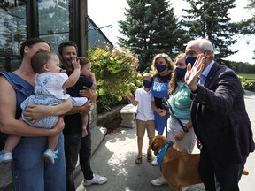 Conservative Leader Erin O'Toole, right, speaks with the cofounders of Dog Tales Rescue and Sanctuary, Danielle and Rob Scheinberg, and their twins Liam and Elise, during a campaign stop in King City, Ont., on Aug. 30, 2021.