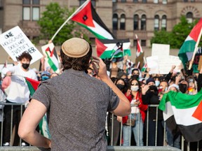 A pro-Israeli supporter gestures towards pro-Palestinian supporters during a demonstration in downtown Toronto on May 15, 2021.