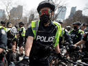 Toronto police officers enforce COVID-19 restrictions at an anti-lockdown protest, April 10, 2021.