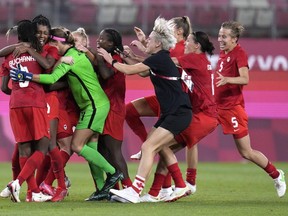Canada's players celebrate after defeating the United States 1-0 during a women's semifinal soccer match at the 2020 Summer Olympics, Monday, Aug. 2, 2021, in Kashima, Japan.