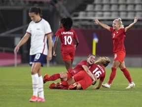 Canada's players celebrate after winning 1-0 to United States during a women's semifinal soccer match at the 2020 Summer Olympics, Monday, Aug. 2, 2021, in Kashima, Japan.