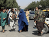 Taliban forces block the roads around the Kabul airport, while a woman passes by, August 27, 2021. After Canada announced its last flight out of Afghanistan, many cooks, guards and translators who had helped Canadians were left stranded.
