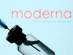 A vial and syringe are seen in front of a displayed Moderna logo in this illustration photo taken on January 11, 2021.