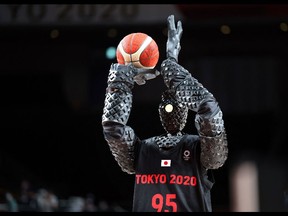 A basketball-playing robot named CUE  plays basketball during half-time of the Men's Preliminary Round Group B game between the United States and France on July 25, 2021, during Tokyo 2020 Olympic Games at Saitama Super Arena. - Toyota has created a 6-foot-10-inch basketball-shooting robot named Cue that uses sensors on its torso to judge the distance and angle of the basket and uses motorized arms and knees to execute set shots. (Photo by Thomas COEX / AFP)