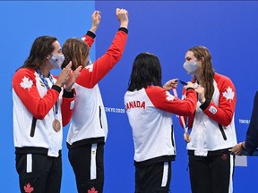 Bronze medallists (from L) Canada's Kylie Masse, Canada's Sydney Pickrem, Canada's Margaret MacNeil and Canada's Penny Oleksiak celebrate with their medals after the final of the women's 4x100m medley relay swimming event during the Tokyo 2020 Olympic Games at the Tokyo Aquatics Centre in Tokyo on August 1, 2021. (Photo by Attila KISBENEDEK / AFP)
