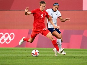 Canada's midfielder Quinn is marked by USA's forward Lynn Williams (R) during the Tokyo 2020 Olympic Games women's semi-final football match between the United States and Canada at Ibaraki Kashima Stadium in Kashima on August 2, 2021.