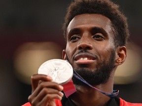 Canada's Mohammed Ahmed celebrates his silver medal on the podium during the medal ceremony for the men's 5000m event during the Tokyo 2020 Olympic Games.