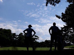 Nelly Korda of Team United States stands with caddie Jason McDede on the 15th fairway during the third round of the Women's Individual Stroke Play.