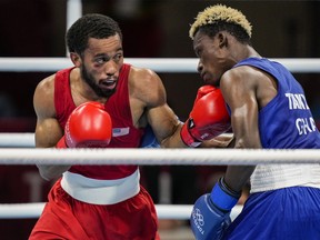 Duke Ragan, left, lands a punch on Ghana's Samuel Takyi in their semifinal match. MUST CREDIT: Washington Post photo by Toni L. Sandys