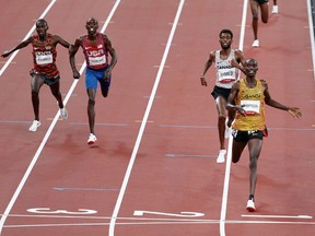 Joshua Cheptegei of Uganda crosses the line to win gold in the 5,000m with Canada's Mo Ahmed in second place.