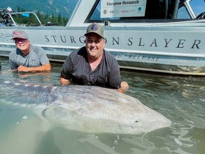 Photo of brothers Barry Bowtell (left) and Bryant Bowtell holding sturgeon in front of the Sturgeon Slayers boat in the Fraser River. Owner and fishing guide Kevin Estrada had ex-NHL'er Pete Peeters and friends out on the Fraser River, north of Chilliwack on Aug. 15, 2021. The group snagged a sturgeon bigger than anything that's been measured in modern history.
