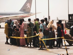 Civilians prepare to board a plane during an evacuation at Hamid Karzai International Airport, Kabul, Afghanistan August 18, 2021.