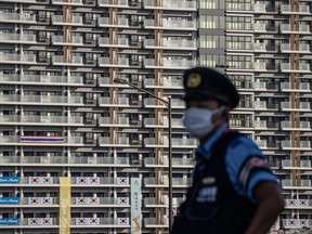 A security guard stands watch at the athletes village at the Olympics on July 20. Organizers had previously said athletes were permitted to drink alcohol only in their rooms and only if they are alone, as a precaution against the virus.