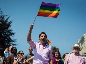 Prime Minister Justin Trudeau waves a rainbow flag while marching in the Pride Parade in Vancouver in 2018.