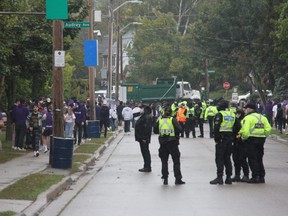 Police officers keep watch on a house party on Broughdale Avenue, near Western University, during a FoCo (Fake Homecoming) party. Photo taken Saturday Sept. 25, 2021. (Jonathan Juha/The London Free Press)