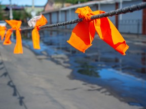 Orange ribbons tied around a cable acknowledging the unmarked graves of Indigenous children recovered at residential school sites across Canada. GETTY