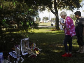 Two women pay their respects at a makeshift memorial dedicated to Gabby Petito, near the North Port, Fla. city hall, on Sept. 20, the day before the body found in Wyoming was identified as Gabby Petito.