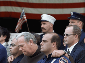 Members of the New York Fire Department embrace at the funeral of Father Mychal Judge, a fire department chaplain who died on duty on September 11, 2001 as the World Trade Center towers collapsed.