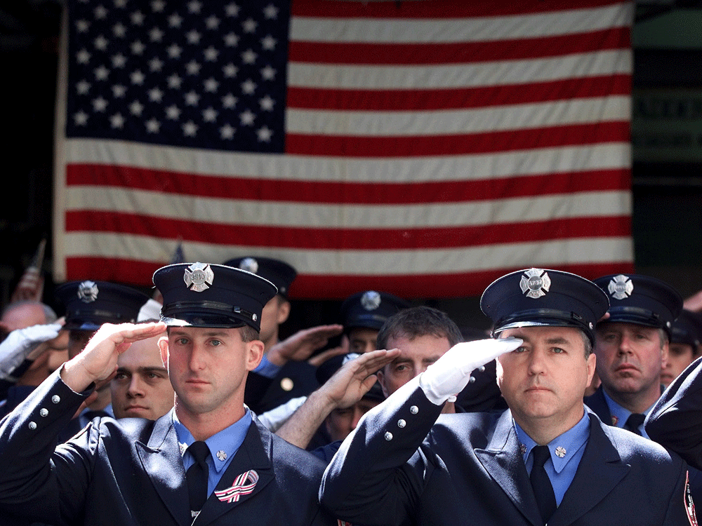  Members of the New York Fire Department salute to the casket of Father Mychal Judge, a fire department chaplain who died on duty on September 11, 2001 as the World Trade Center towers collapsed.