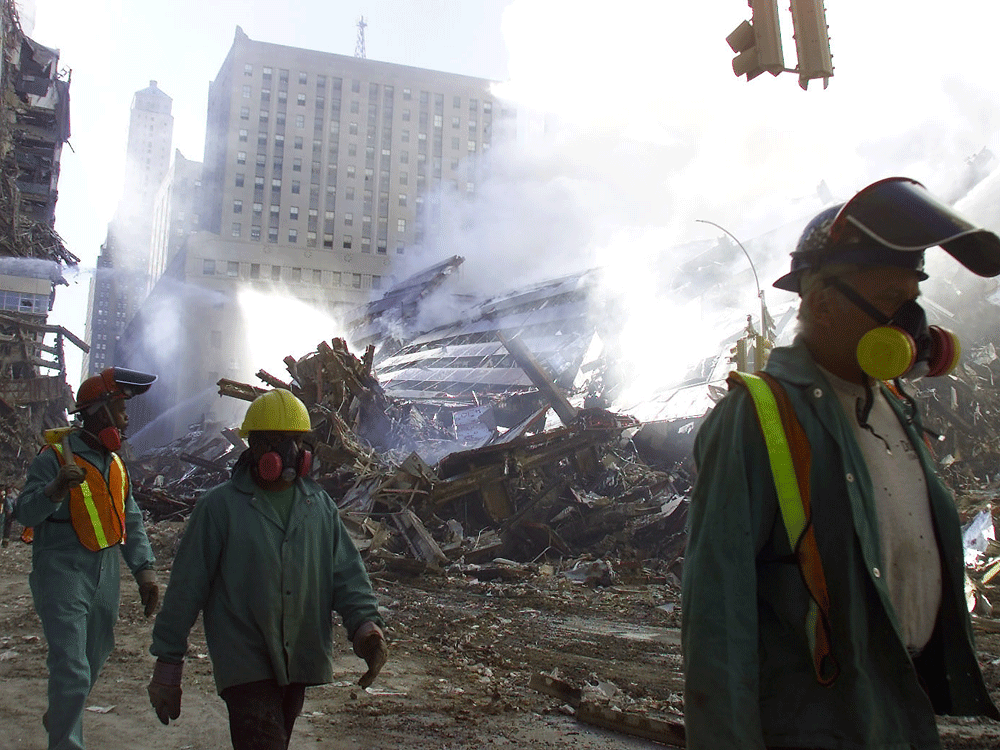  Rescue workers walk the dust lined streets of Manhattan as fires still burn from the World Trade Centre on Wednesday, September 12/2001.