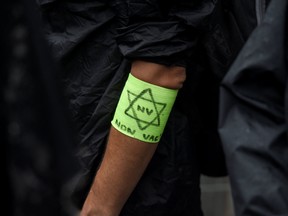 A man wears a yellow armband with a Star of David reading "not vaccinated," during a demonstration against compulsory vaccination for certain workers and the French health pass, in Nantes, France, on July 24.