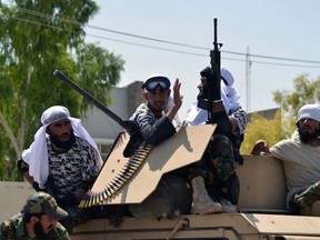 Taliban fighters atop a Humvee vehicle parade along a road to celebrate after the US pulled all its troops out of Afghanistan, in Kandahar on September 1, 2021 following the Talibans military takeover of the country.