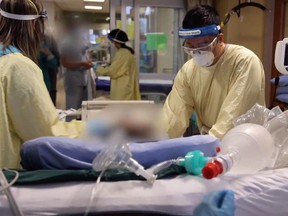 Calgary ICU staff working on patients in a crowded ICU.