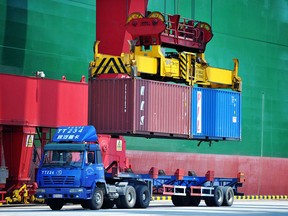 Containers are transferred at a port in Qingdao in China's eastern Shandong province in a file photo from July 6, 2018.