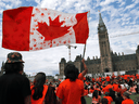 Protesters wave a flag at Parliament Hill in Ottawa at a 