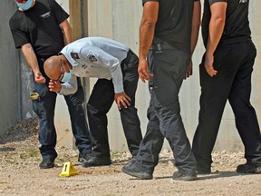 Head of Israel Prison Service Arik Yaakov (C) looks at an evidence outside the Gilboa Prison in northern Israel on September 6, 2021.