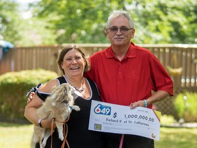 Rick and Sandra Porter pose with their rescue dog and $1 million OLG novelty cheque in their backyard.