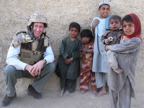 Then Canadian defence minister Peter Mackay poses with 10-year-old Khedayyatullak and his four siblings beside a Canadian army road-building project employing 400 Afghans in Kandahar, Afghanistan, on March 19, 2008.