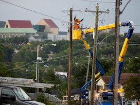 Electric company workers fix broken power lines and poles after Category 1 Hurricane Larry hit St. John's, Newfoundland, on Sept. 11.
