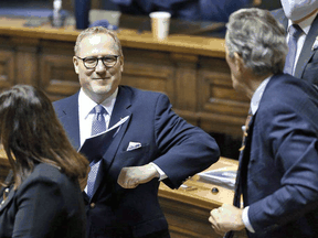 Manitoba Finance Minister Scott Fielding, left, elbow bumps then-Premier Brian Pallister after the provincial budget was reled in the Manitoba Legislature on Wed., April 7, 2021.