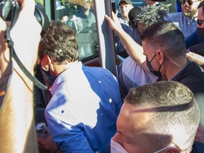 Stones strike  Prime Minister Justin Trudeau in the back and head as he boards his bus at the end of a campaign stop at the  London Co-Operative Brewing Company in London, Ont. on Monday September 6, 2021.