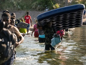 Migrants seeking asylum in the U.S. walk in the Rio Grande river near the International Bridge between Mexico and the U.S., as they wait to be processed, in Ciudad Acuna, Mexico, Sept. 17.