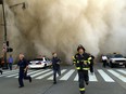 Policemen and firemen run away from the huge dust cloud caused as the World Trade Center's Tower One collapses after terrorists crashed two hijacked planes into the twin towers, September 11, 2001 in New York City.