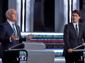 Liberal leader Justin Trudeau listens as Conservative Party leader Erin O'Toole speaks during the federal election French-language leaders debate, in Gatineau, Quebec, Canada September 8, 2021.