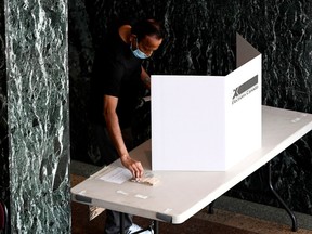 A voter picks up a pencil to cast their ballot at a polling location on election day during the 44th Canadian general election, on Monday, Sept. 20, 2021.