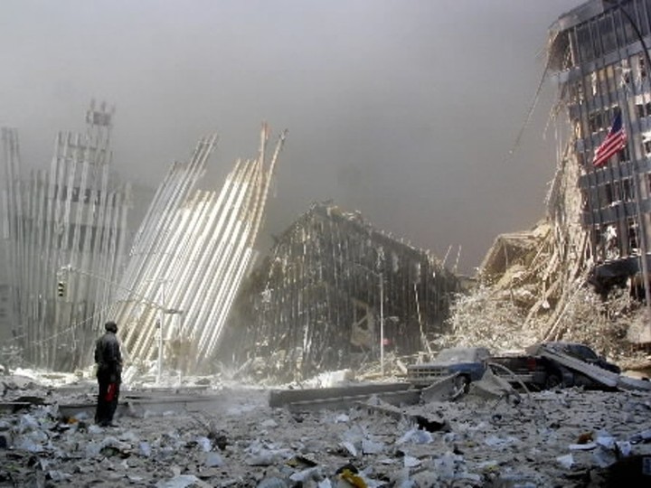  This 11 September 2001 file photo shows a man standing in the rubble, and calling out asking if anyone needs help, after the collapse of the first World Trade Center Tower in New York City.