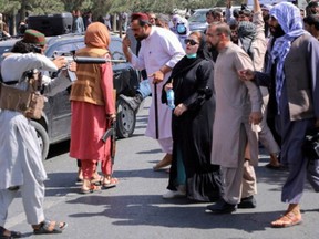 A member of the Taliban forces points his gun at protesters, as Afghan demonstrators shout slogans during an anti-Pakistan protest, near the Pakistan embassy in Kabul, Afghanistan September 7, 2021.