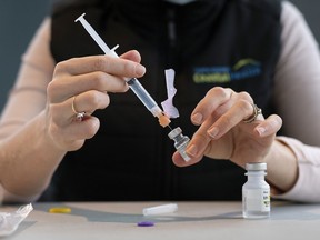 A healthcare worker fills a low-dead space syringe with the Pfizer-BioNTech Covid-19 vaccine at a vaccination clinic. (Jennifer Gauthier/Bloomberg )