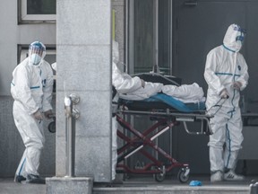 Medical staff members carry a patient into the Jinyintan hospital, where people infected by a mysterious SARS-like virus were being treated, in Wuhan, China, on Jan. 18, 2020.