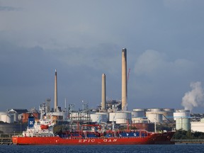 An LNG tanker sails past a refinery in Fawley, England, on Oct. 4.