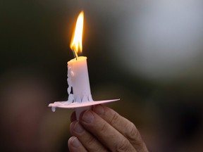 A man holds a candle during a vigil for cinematographer Halyna Hutchins, who was accidentally killed by a prop gun fired by actor Alec Baldwin, in Burbank, California on October 24, 2021.