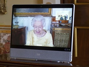 Queen Elizabeth appears on a screen via videolink from Windsor Castle, where she is in residence, during a virtual audience  Tuesday.